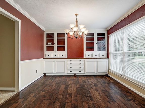 UPON ENTERING, THE FORMAL DINING ROOM IS TO THE RIGHT, FEATURING HANDSCRAPED WOOD FLOORS AND CUSTOM BUILT-INS WITH GLASS FROM CABINETS.