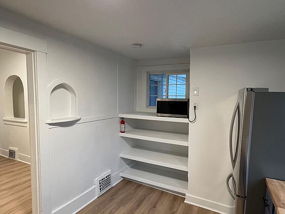 Bright kitchen and dining area with open shelving, updated finishes, and an open flow into the living space.