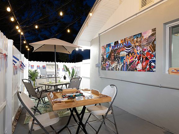 Patio Area With BBQ, And Table with Umbrella And $ Chairs.
