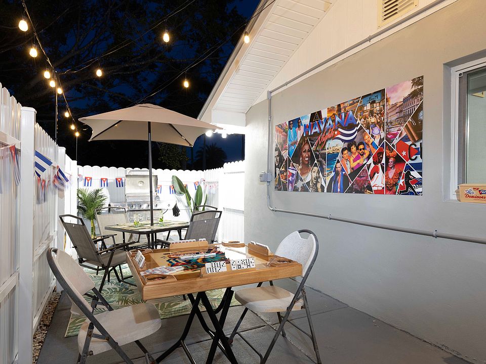 Patio Area With BBQ, And Table with Umbrella And $ Chairs.