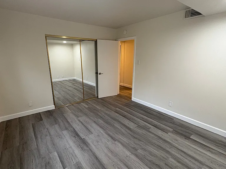 In Master Bedroom, looking back toward entry door and mirrored, sliding glass door closet