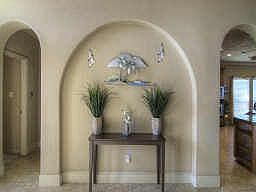 The stunning entry features a double pop-up ceiling with crown molding detail, designer ceiling fan 