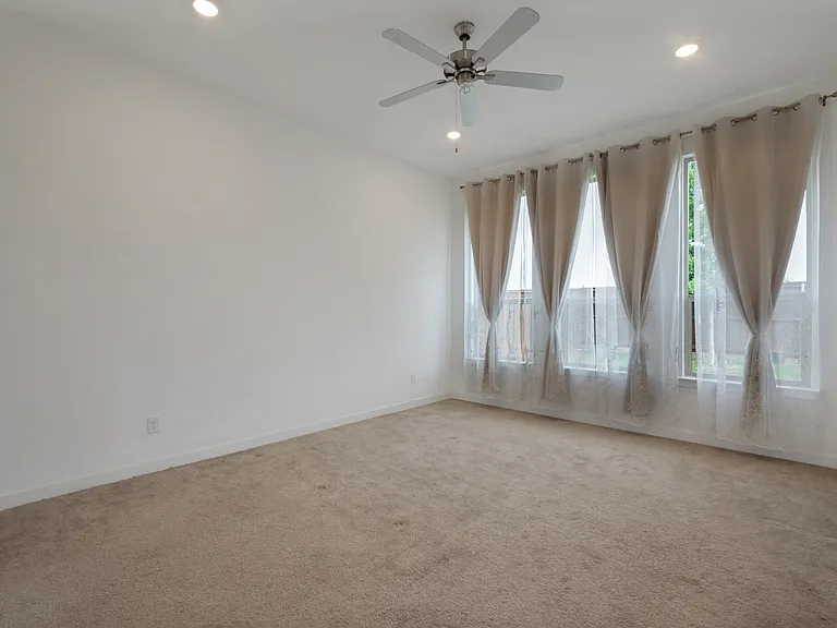 The private first-floor primary suite offers a spa-like sanctuary featuring dual vanities, a soaking tub, a separate standing shower, and an expansive walk-in closet.