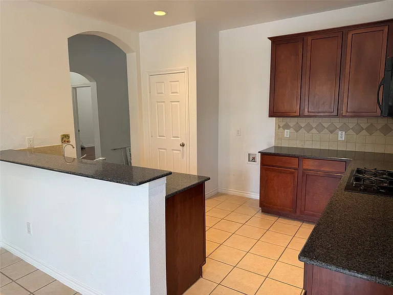 Kitchen with arched doorway.