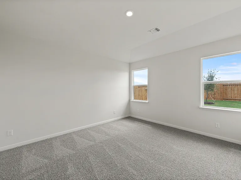 The spacious master bedroom has a large window that lets in natural light and backyard views.