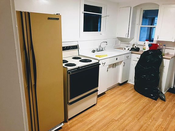 Kitchen with appliances and laminate flooring.