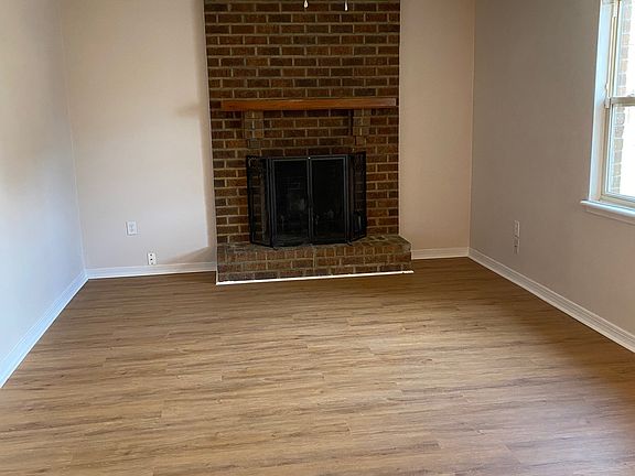 Living room with wood burning fireplace. Brand new luxury vinyl plank flooring throughout the unit. No carpet anywhere.