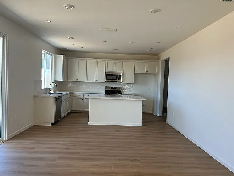 Kitchen: A stunning modern kitchen with a center island, crisp white cabinetry, quartz counters, and a subway-tile backsplash _ the heart of the home.