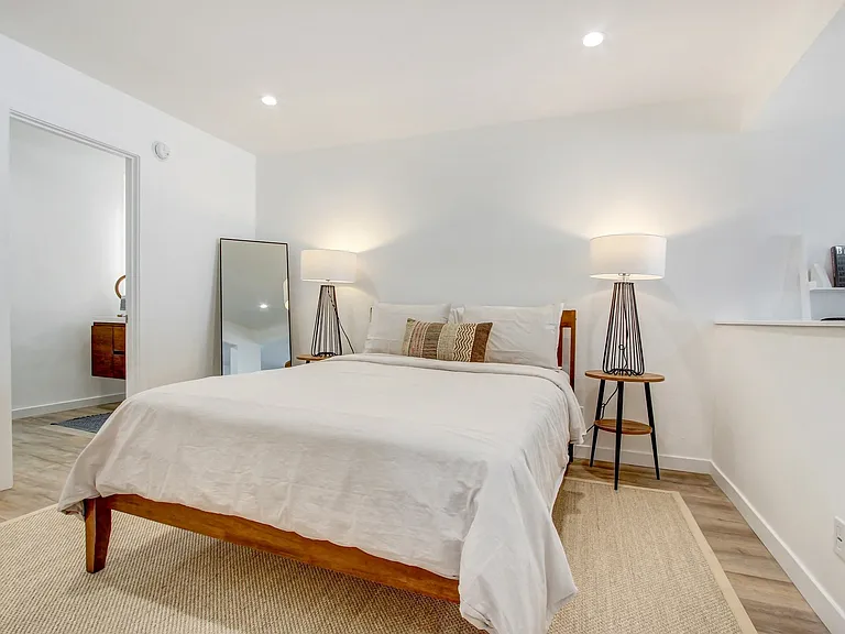 Sleeping area with recessed lights, plank flooring