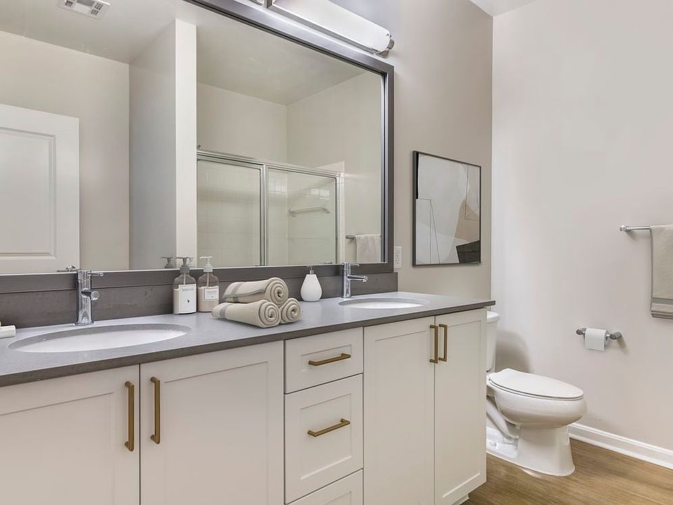 Renovated Package II bath with grey quartz countertops, white cabinetry, and hard surface flooring