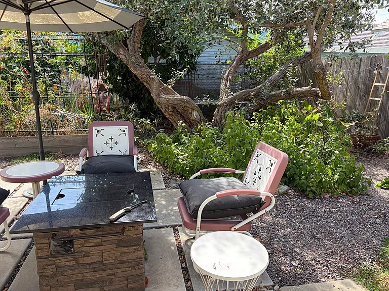 Enjoy this Gorgeous Backyard filled with Fruit Trees, Colorful Flowers, and a Firepit Seating Area as part of your tranquil living experience in this Charming 2 BDR/1 BA Retro Row Duplex Apartment.