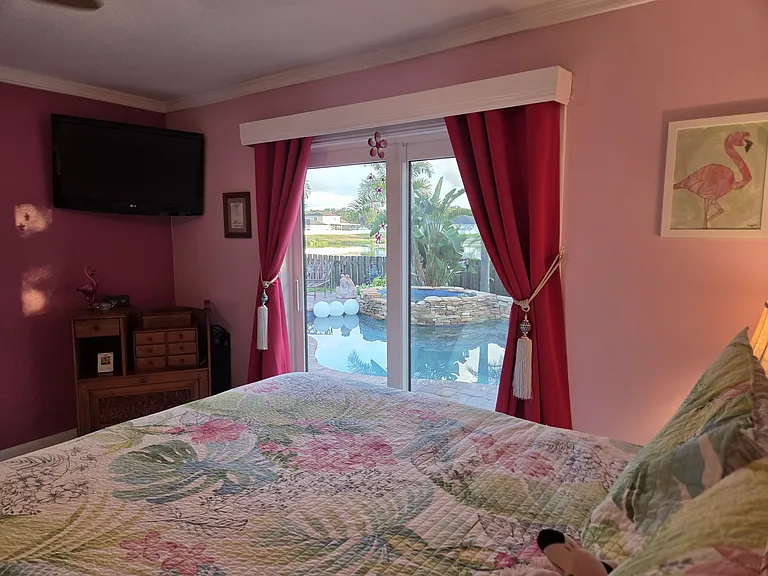 Master bedroom with slider door access to pool area