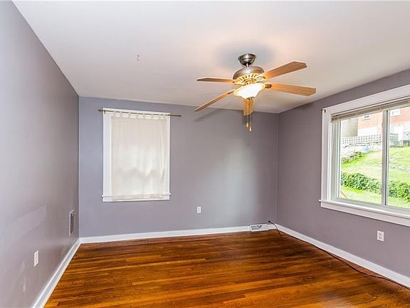 Master bedroom on 2nd level has a muted gray decor, gleaming hardwood floors & new windows to let in the sunlight.