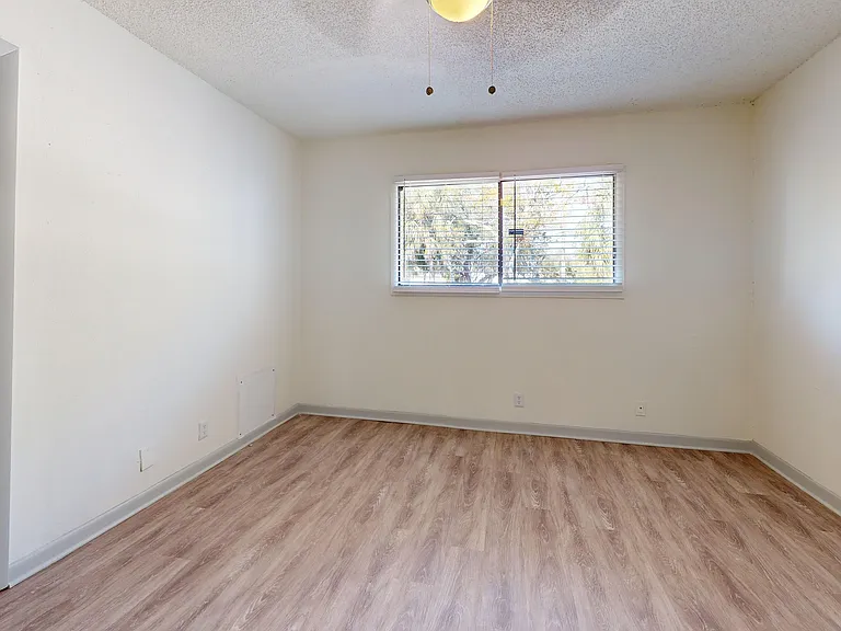 Experience comfort and tranquility in this bright, airy bedroom equipped with elegant wooden floors.
