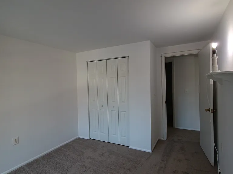 second bedroom with a closet and new carpeted area