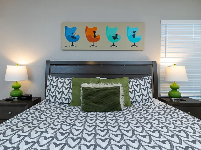 Primary bedroom with king size bed, dresser and fireplace.