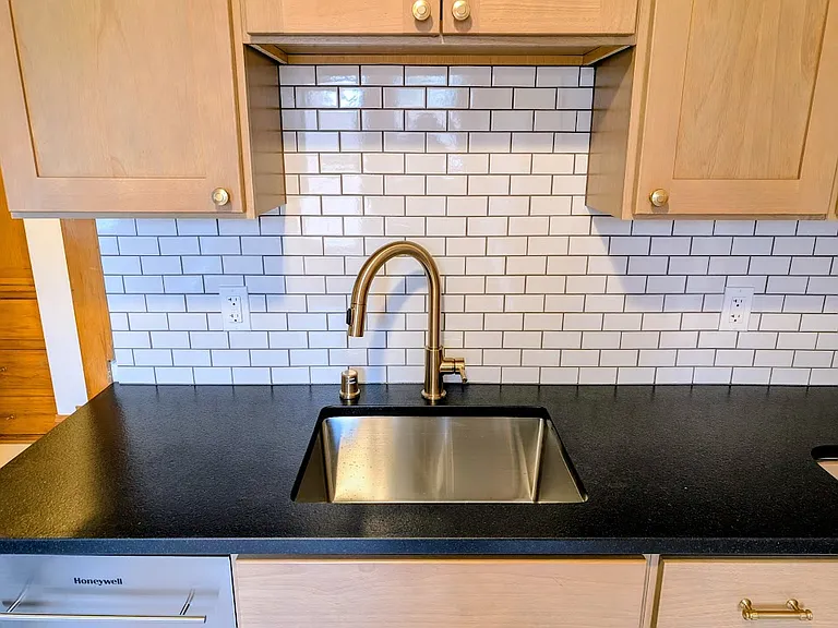 [UPPER UNIT]: Newly remodeled kitchen with stainless steel appliances, leathered granite countertops, solid wood cabinets, luxury vinyl tile flooring with Carrara Marble aesthetic, champagne gold fixtures