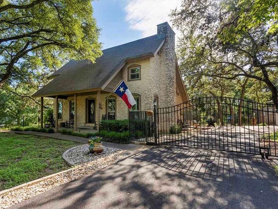 Front view showing main home and how it's detached from separate garage apartments. Parking spots are located in front of the gate, not behind.