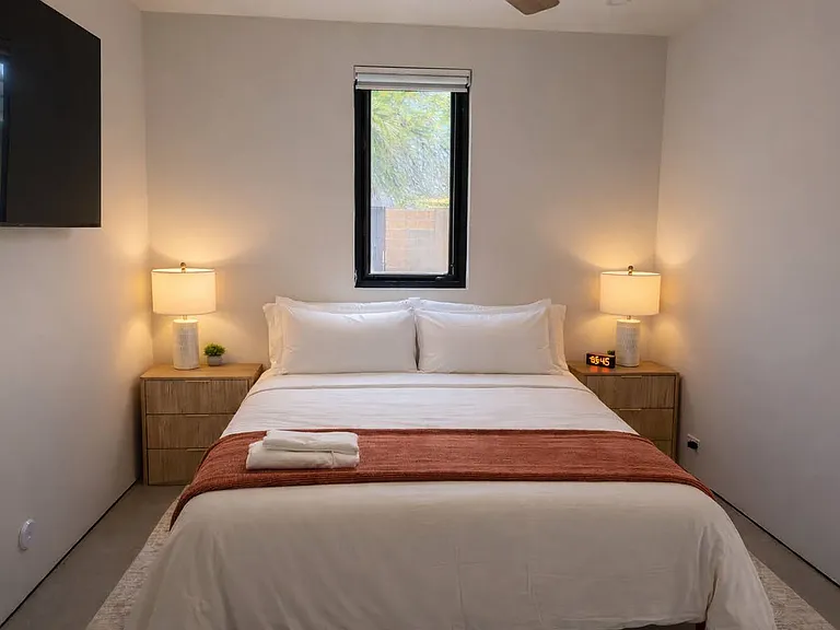 Inviting queen guest bedroom with plush bedding, soft lighting, and a peaceful, minimalist aesthetic.