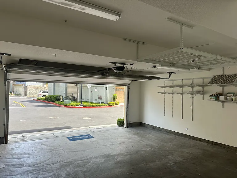 Generous 2-car garage with custom wall storage shelving and overhead roof storage