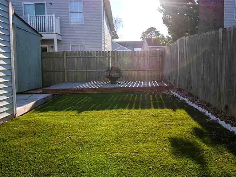 Side yard viewpoint from about mid-house; the fence has double doors (behind me) that open up from this artificial grass towards the front yard