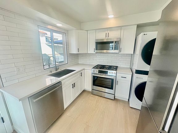 Full sized fridge/freezer, stackable washer/dryer, microwave, 5 burner stove/oven, dishwasher, and farmhouse sink with garbage disposal and pull down faucet.