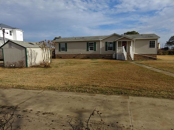 Front of the house with a concrete driveway to park two cars. A pump house for storage.