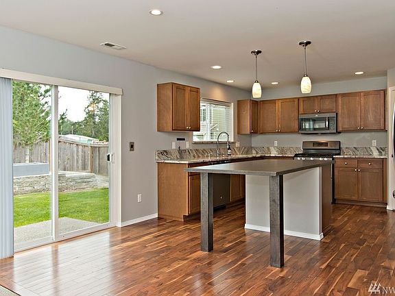 Kitchen features artisan concrete island with dining space, large pantry and granite counters. 