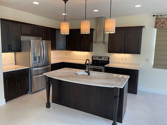 Kitchen with solid surface countertops and marble top island.