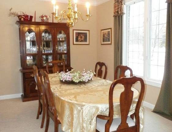 The dining room measures 11'x 13' with formal details of crown molding, forette, and custom drapes.