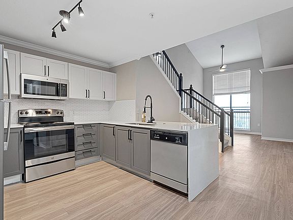 Spacious kitchen with hardwood style flooring and stainless steel appliances