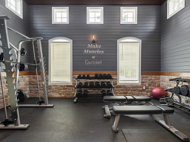 Inviting home gym with state-of-the-art equipment, sleek gray walls, and motivational decor, perfect for fitness enthusiasts.