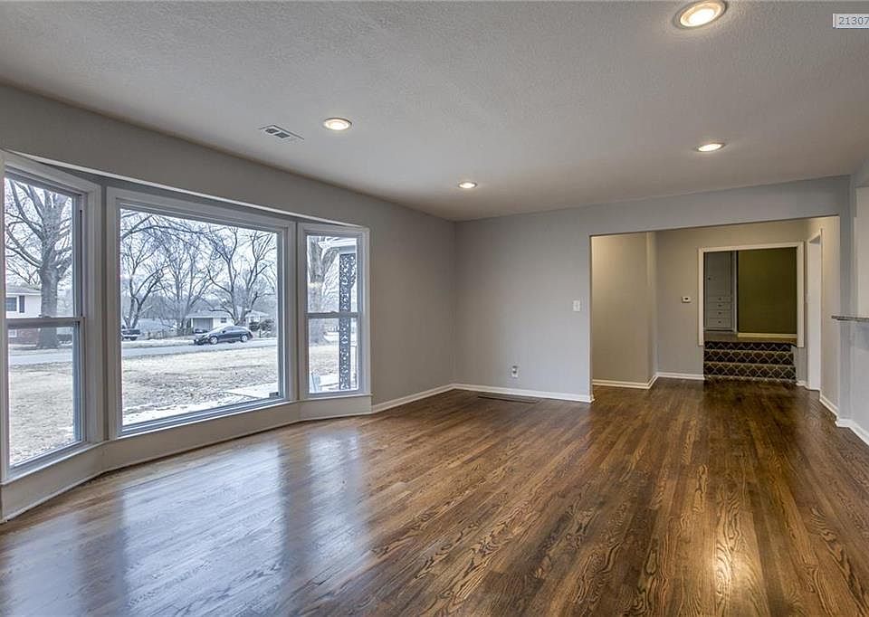 A full wall of picture windows bringing in natural lighting with shimmering hardward floors.