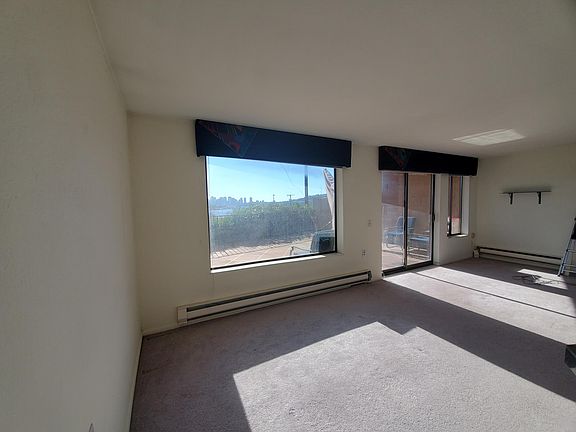 Living room picture window with view of Lake Union and space needle. Slider leads to large deck