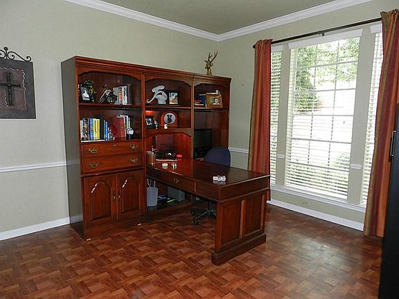 Formal Living room could double as study with double French doors, crown molding, chair rail, wood flooring, 2" blinds and accent drapes.