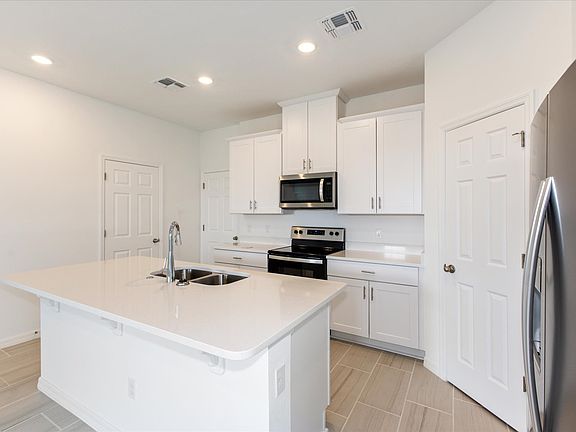 Kitchen in the Hurston floorplan at 4613 Cross Prairie Parkway in The Meadow at Crossprairie