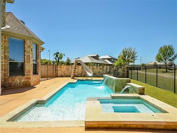 Pool with hot tub, fountain feature and slide.