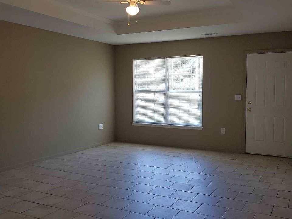 Living room front window & door. Tile floors and ceiling fan.