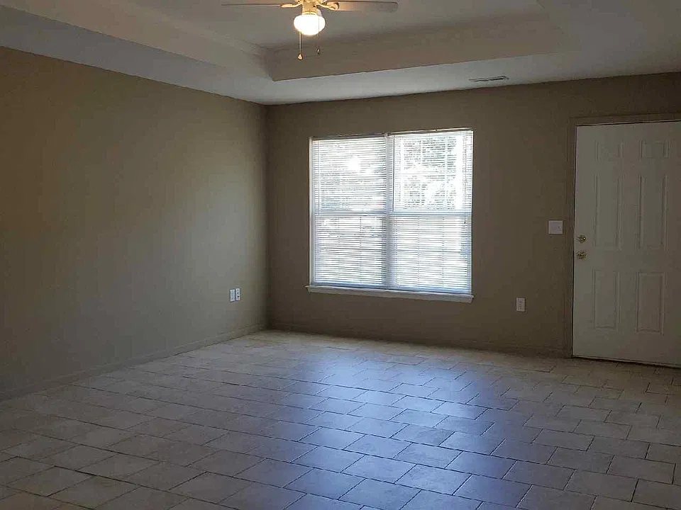 Living room front window & door. Tile floors and ceiling fan.