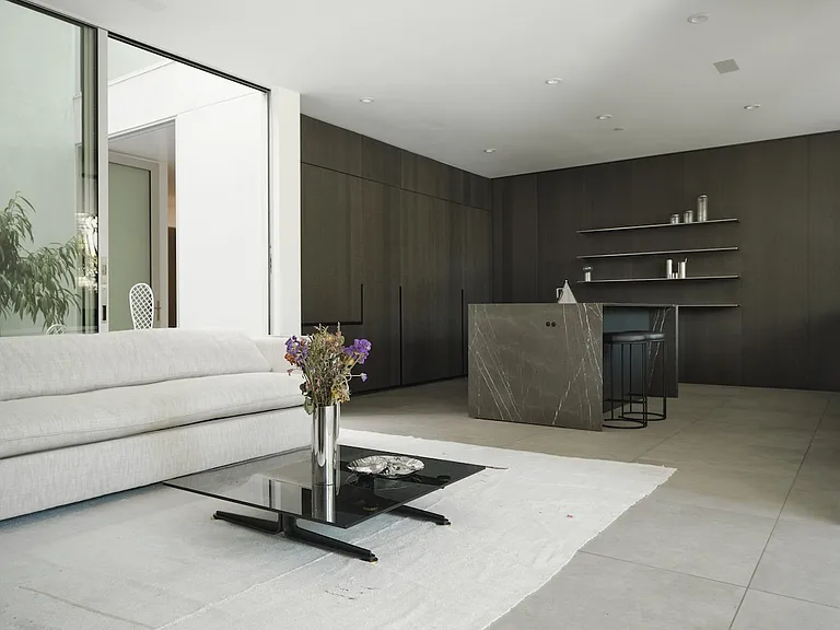 Open-Concept Living with Designer Kitchen _ A seamless blend of modern elegance and functionality, this space features custom dark cabinetry, a striking marble island, and sleek open shelving.