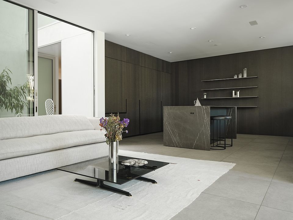Open-Concept Living with Designer Kitchen _ A seamless blend of modern elegance and functionality, this space features custom dark cabinetry, a striking marble island, and sleek open shelving.