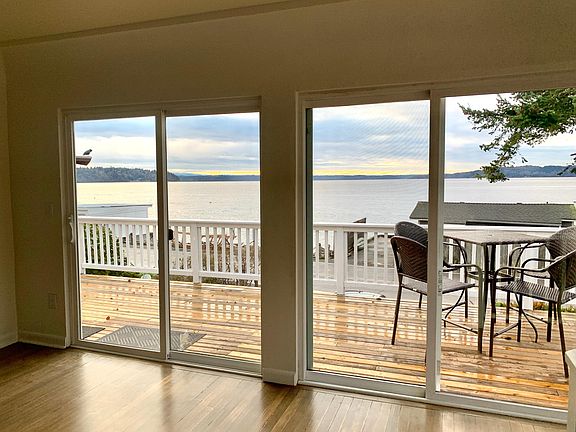 Sliding windows open to expansive view deck overlooking the Puget Sound with Mt. Rainier off in the distance.