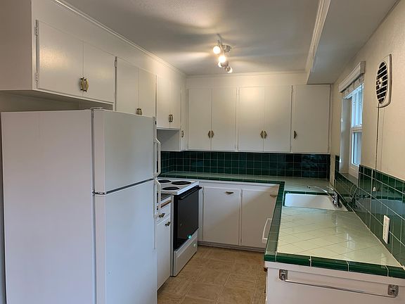 Kitchen with original cabinetry and tiling. Dishwasher included.