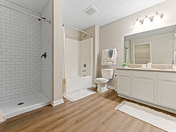 Relax in a spa-inspired bathroom with double vanity and walk-in shower for a luxurious living experience in Akron
