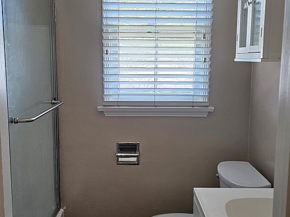 View of Bathroom with new Sliding Glass Shower Door Custom paint and Faux Wood Blinds