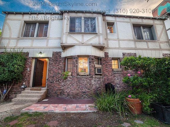 Patio is to right of door with shrubs, trees for privacy
