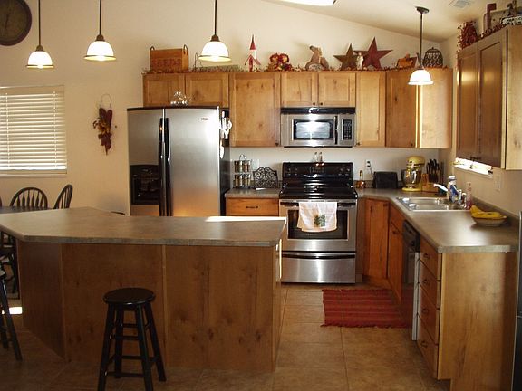 Kitchen feature knotty alder cabinets and stainless appliances