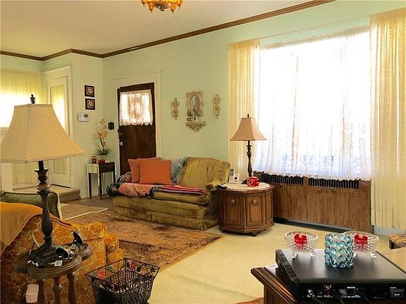 Light and bright throughout with crown molding, original front door and hardwoods under carpet.