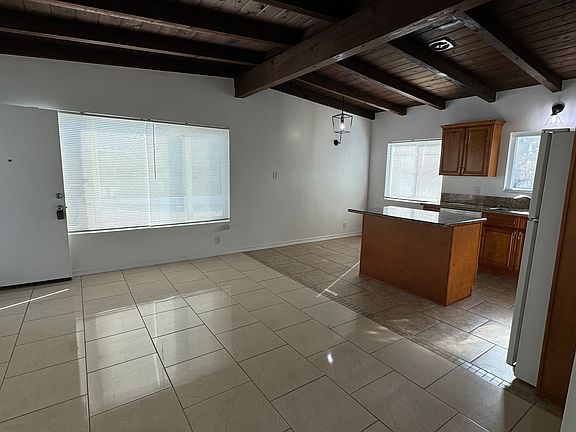View from the hall towards the front door, living room, dining room and kitchen areas.