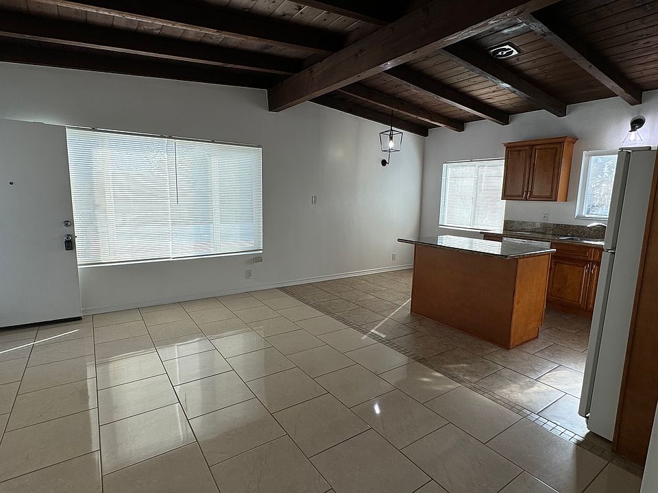 View from the hall towards the front door, living room, dining room and kitchen areas.